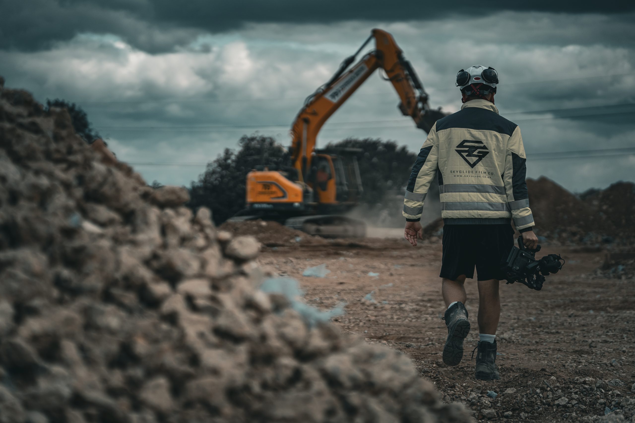 SkyGlide camera operator on site as an excavator works behind